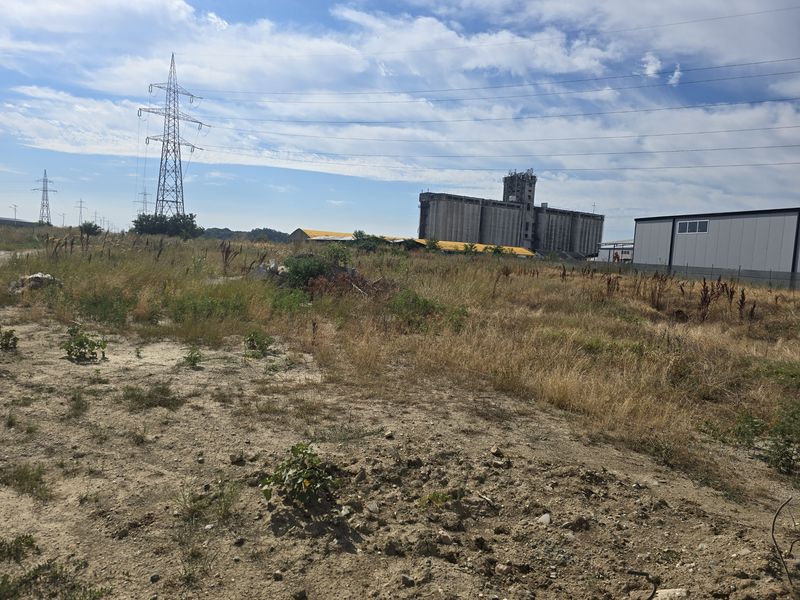 View across the undeveloped land towards power pylons and neighbouring industrial buildings