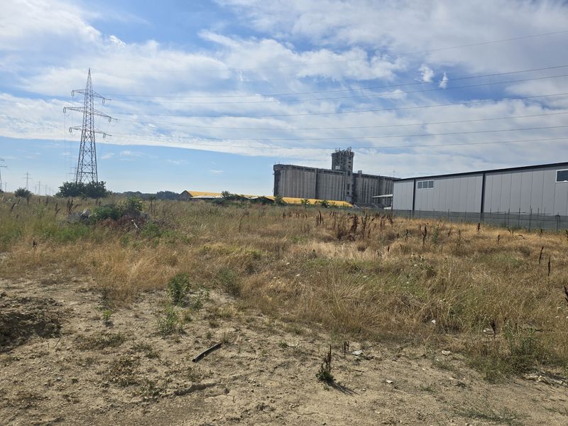View across the site with power lines and adjoining industrial buildings
